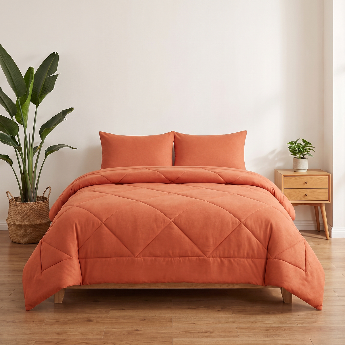 The 2-in-1 Comforter in Sunset Orange on a made bed