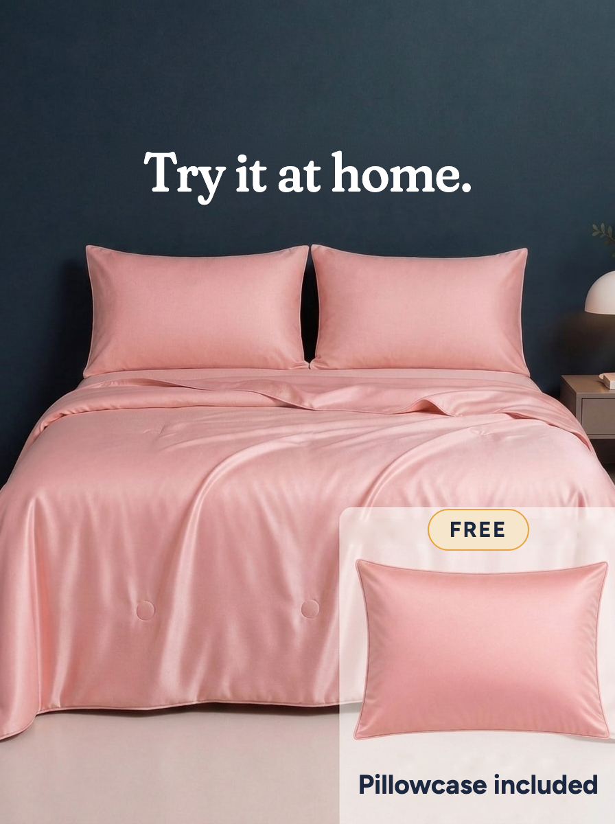 The Cooling Comforter in Frost Pink on a made bed · Try it at home · Free · Pillowcase included